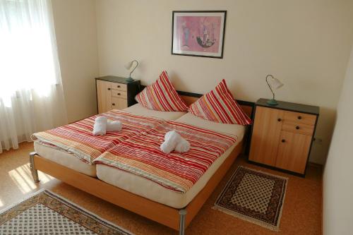 - une chambre avec un lit doté d'oreillers rouges et blancs dans l'établissement Ferienwohnung Kastl, à Kastl