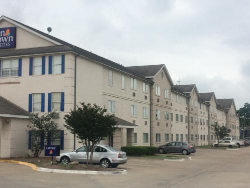 a large apartment building with cars parked in a parking lot at InTown Suites Extended Stay Select Houston TX - BrookHollow in Houston