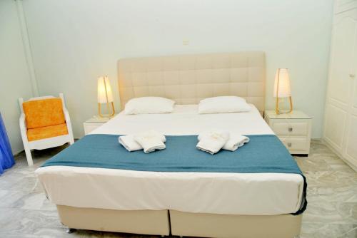 a bedroom with a large bed with two towels on it at Saint Nicholas Beach Resort in Dassia