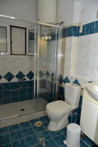 a bathroom with a toilet and a shower and a sink at Saint Nicholas Beach Resort in Dassia