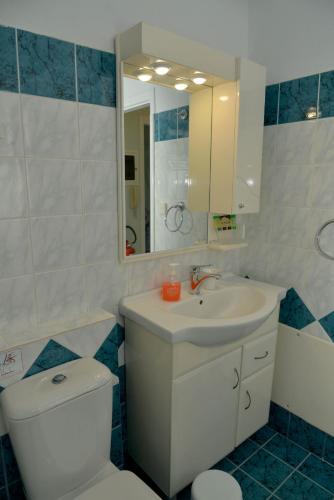 a bathroom with a sink and a toilet and a mirror at Saint Nicholas Beach Resort in Dassia