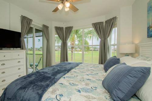 a bedroom with a bed and a television and windows at GreenLinks Golf View Villa Mustang at Lely Resort in Naples