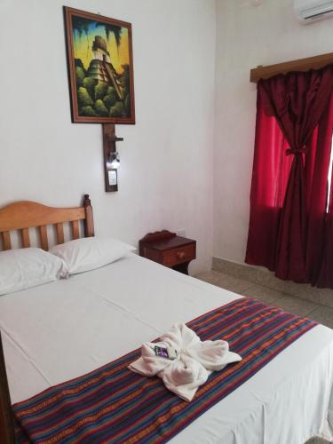 a bedroom with a white bed with a towel on it at Hotel La Union in Flores