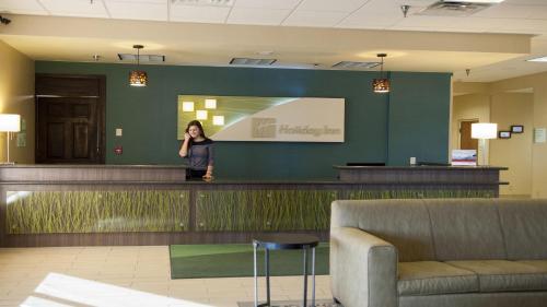 a woman standing behind a counter in a lobby at Holiday Inn Spearfish-Convention Center by IHG in Spearfish