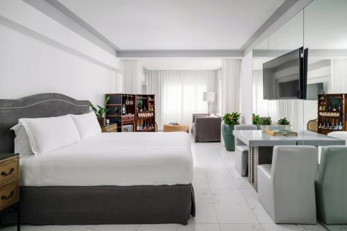 a bedroom with a large bed and a living room at Nautilus Sonesta Miami Beach in Miami Beach