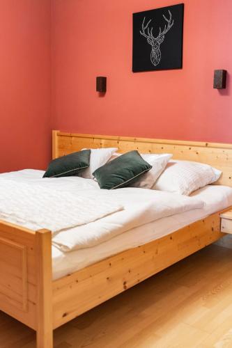 a wooden bed in a room with a red wall at Ski in - Ski out Schladming NEM Alpin Chalet in Schladming