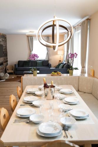 a dining table with plates and wine glasses on it at Ski in - Ski out Schladming NEM Alpin Chalet in Schladming