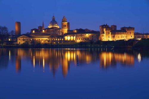 a large building with lights illuminating the water at night at Agriturismo Il Brugnolo in Scandiano