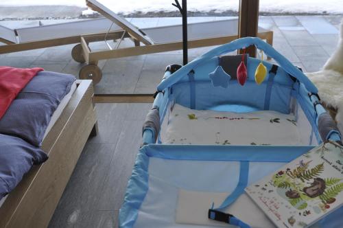 a baby crib sitting next to a bed at Casa Admisa, spektakuläre Aussicht, Ski in and out, hochwertige Einrichtung, Valserstein und Eiche in Flims