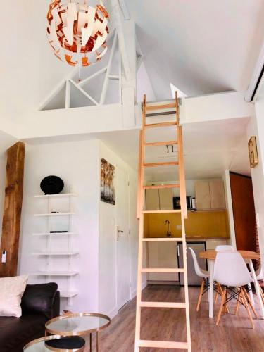 a living room with a loft bed and a table at Ad libitum in Les Ageux