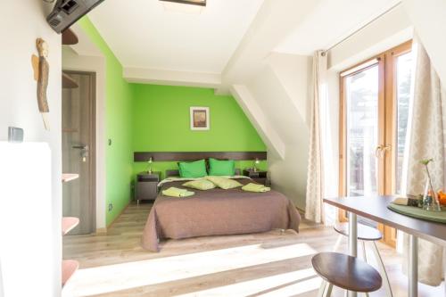 a bedroom with green walls and a bed at Willa w Ubocy - "Jacuzzi i Sauna w ofercie dodatkowo płatnej" in Murzasichle