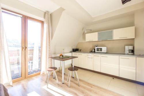 a kitchen with white cabinets and a table with stools at Willa w Ubocy - "Jacuzzi i Sauna w ofercie dodatkowo płatnej" in Murzasichle