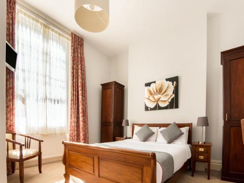 OYO the Regency, Clifton Bristol في بريستول: غرفة نوم بسرير كبير ونافذة