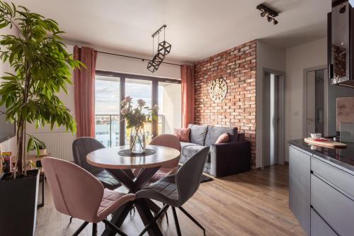a kitchen and living room with a table and chairs at Glamour Apartment City View in Wrocław