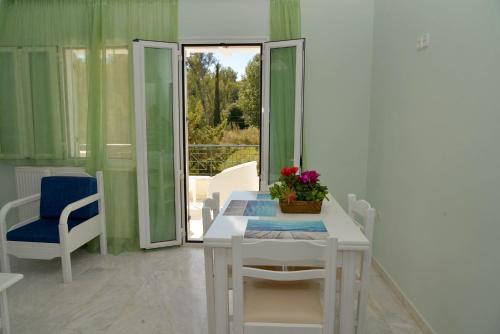 a room with a white table and chairs and a window at Saint Nicholas Beach Resort in Dassia