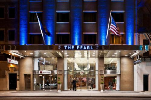
a large building with a clock on the front of it at The Pearl Hotel in New York
