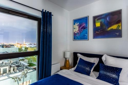 una camera con un letto e una grande finestra di Glamour Apartment City View a Breslavia