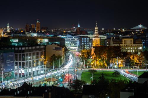 a city lit up at night with traffic at Glamour Apartment City View in Wrocław