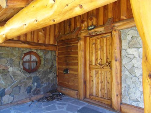 Cabaña con puerta de madera y pared de piedra en La Cabaña de Juan en Villa Traful