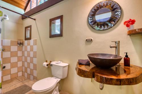 a bathroom with a toilet and a sink at Caribe Town Bungalows in Puerto Viejo