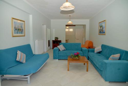a living room with two blue couches and a table at Saint Nicholas Beach Resort in Dassia