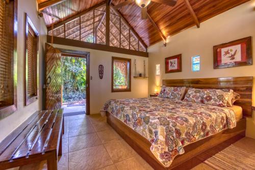 a bedroom with a large bed and a large window at Caribe Town Bungalows in Puerto Viejo