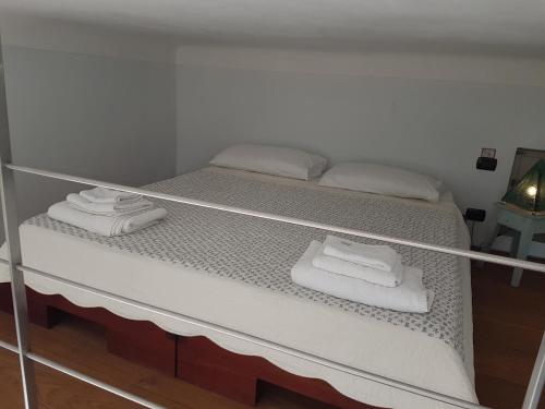 uma cama com toalhas brancas em cima em Le Palmaro em Menton