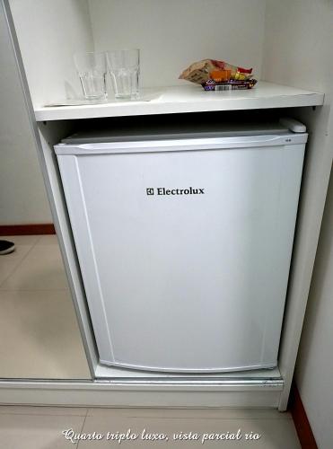 a refrigerator with a shelf on top of it at Pousada Molhes da Barra in Torres