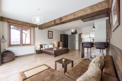 a living room with a couch and a bed at Willa w Ubocy - "Jacuzzi i Sauna w ofercie dodatkowo płatnej" in Murzasichle