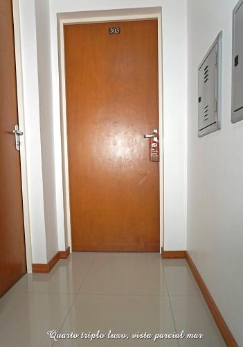 a brown door in a room with a tile floor at Pousada Molhes da Barra in Torres