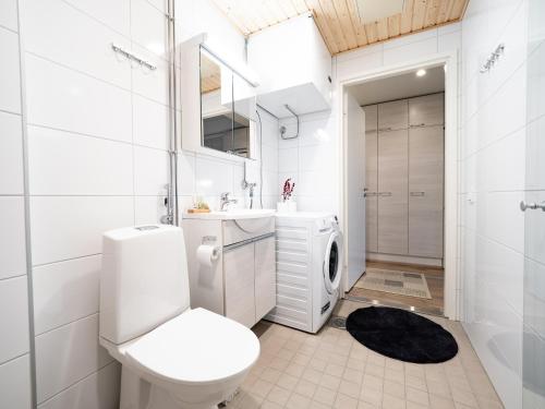 a white bathroom with a toilet and a sink at First Aparthotel Comet in Rovaniemi