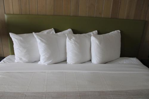 a group of white pillows sitting on a bed at Country Inn & Suites by Radisson, London, KY in London