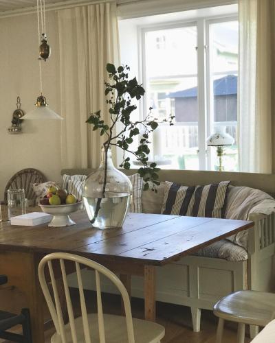 a dining room table with a vase with a plant on it at Pensionatet in Piteå