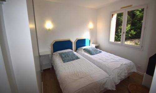 two beds in a small bedroom with a window at VILLA PECH DE DURAND VILLENEUVE SUR LOT in Villeneuve-sur-Lot
