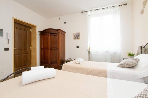 a bedroom with two beds and a window at Le Camere Di Aladino in Carugate