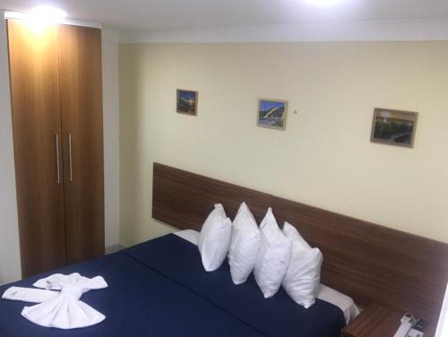een hotelkamer met een blauw bed met witte kussens bij Ponta Negra Beach Praiano Flat in Natal