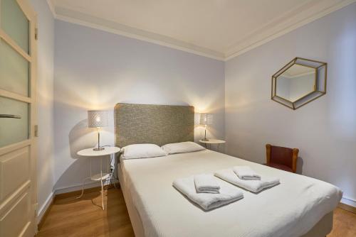 a bedroom with a large white bed with towels on it at Aesthetic Riverview Apartment in Historical Lisbon in Lisbon