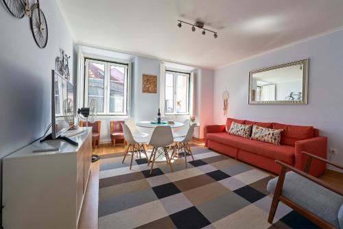 a living room with a red couch and a table at Aesthetic Riverview Apartment in Historical Lisbon in Lisbon