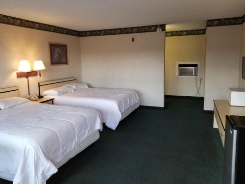 a hotel room with two beds and a desk at TravelStar Inn & Suites in Colorado Springs