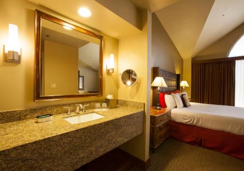 a hotel room with a bed and a sink and a mirror at Ventana Canyon Club and Lodge in Tucson
