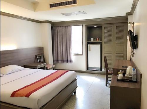 a hotel room with a bed and a desk and a television at Bangkok Loft at Nana Station in Bangkok