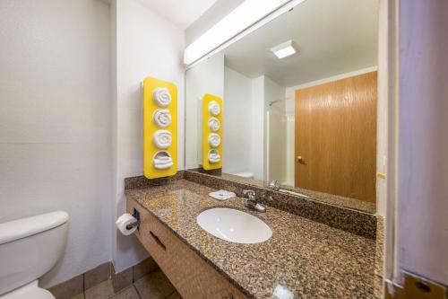 a bathroom with a sink and a toilet and a mirror at Motel 6-Decatur, TX in Decatur