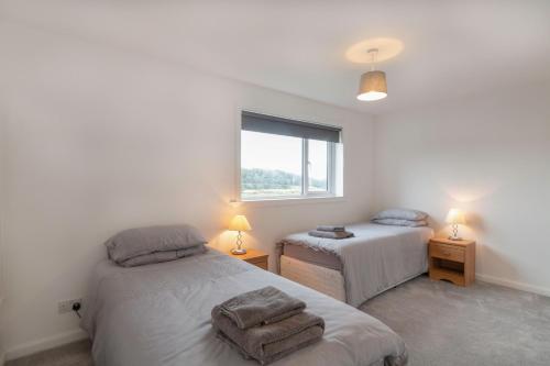 a bedroom with two beds and a window at Grampian Serviced Apartments - Park View in Elgin
