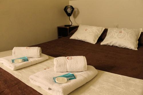 
a bed with two pillows and a blanket on top of it at Casi Guemes Hotel in Córdoba
