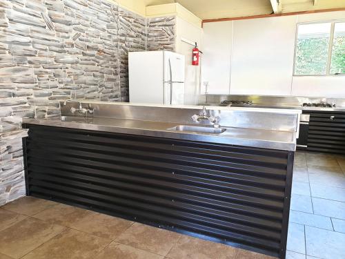 a kitchen with a stainless steel counter with a sink at Lake Ruataniwha Holiday Park in Twizel