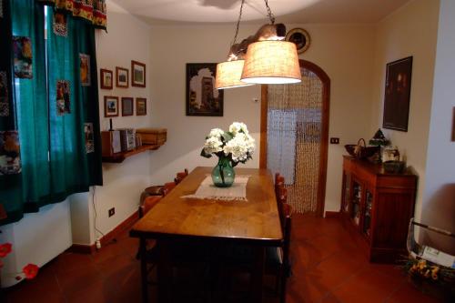 Il Sorriso Dei Monti في Orvinio: غرفة طعام مع طاولة مع الزهور في مزهرية