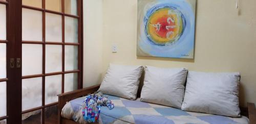 a couch with pillows in a room with a painting at CITY BELL DUPLEX PLAZA in City Bell