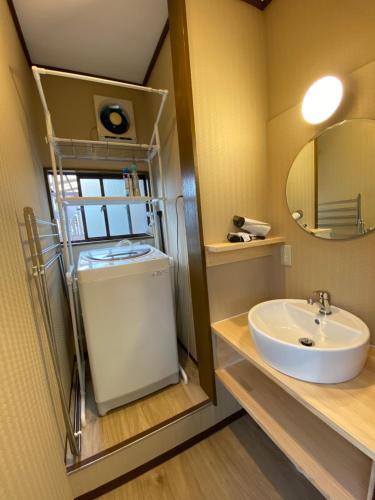 La salle de bains est pourvue d'un lavabo et d'un miroir. dans l'établissement HOTEL Japonica, à Tokyo