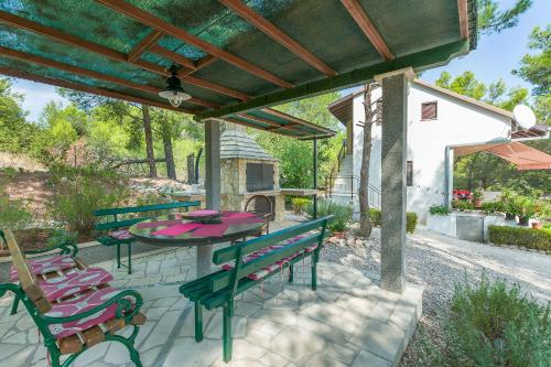 a patio with a table and chairs and a fireplace at Apartment Ametist in Milna