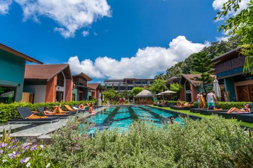 a pool at a resort with people sitting around it at ChaoKoh Phi Phi Hotel and Resort- SHA Extra Plus in Phi Phi Don